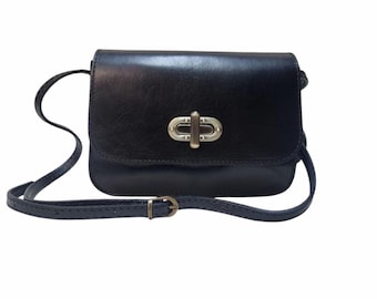 May include: A black leather crossbody bag with a silver clasp. The bag has a long adjustable strap.