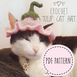 May include: A white and black cat wearing a pink crocheted tulip hat with green leaves. The hat has a ruffled edge. The cat is lying down and looking to the side. The text "CROCHET TULIP CAT HAT PDF PATTERN" is written in black on a white background.