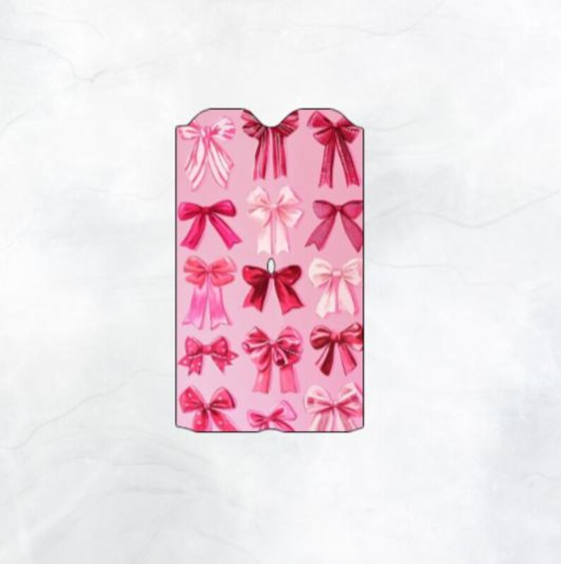 May include: A pink card with a pattern of pink and red bows. The card has a scalloped edge.