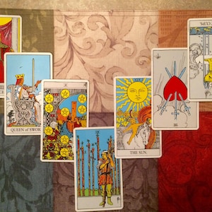 May include: A collection of tarot cards, including "Justice," "Queen of Swords," "Ten of Pentacles," "The Sun," "Three of Swords," "Ace of Cups," and "Nine of Wands." The cards are arranged on a patterned surface with a mix of colors and designs.