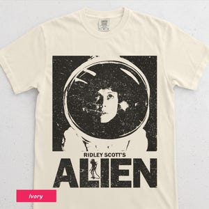 以下が含まれることがあります： アイボリー色のTシャツ。リドリー・スコットの「エイリアン」の、使い古された白黒グラフィックが特徴です。グラフィックには、宇宙ヘルメットをかぶった人物の肖像と映画のタイトルが含まれています。このシャツはComfort Colorsブランドです。