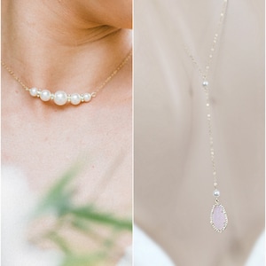 May include: A gold necklace with a row of pearls and a matching gold chain necklace with a pink teardrop pendant. The jewelry is delicate and elegant, perfect for a special occasion.