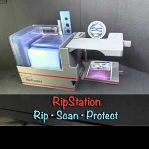 Puede incluir: Un organizador RipStation gris impreso en 3D que cuenta con un compartimento de almacenamiento para fundas de tarjetas transparentes, una plataforma de escaneo con una tarjeta colocada y un logotipo circular. Incluye una regla azul y un bolígrafo.