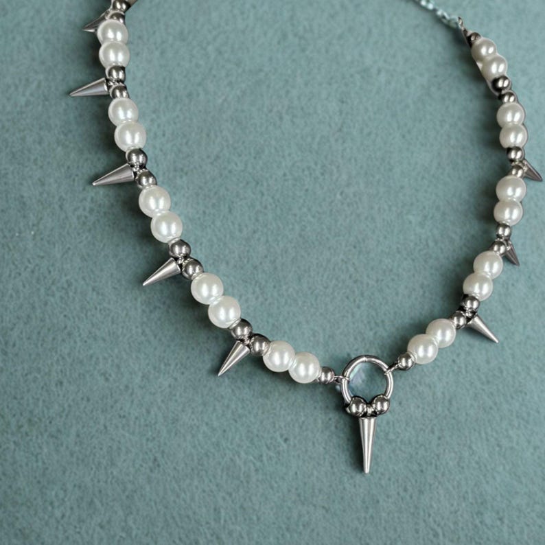 Punk pearl spike choker necklace with stainless steel beads on display stand