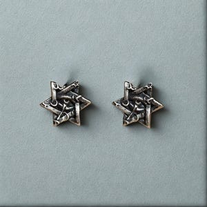 Può includere: Un set di tre tazze in ceramica con finitura opaca e macchiettata. Le tazze sono nei toni del crema, grigio chiaro e grigio scuro. Ogni tazza ha un design semplice e minimalista.