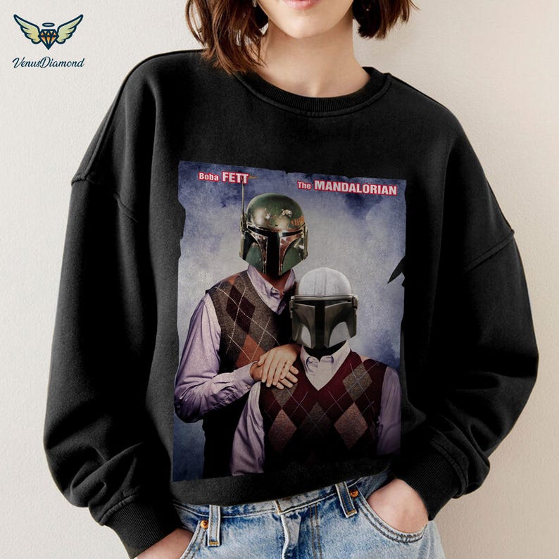 May include: Black sweatshirt with a graphic print of Boba Fett and The Mandalorian characters from Star Wars. The text "Boba Fett" and "The Mandalorian" are printed on the graphic.