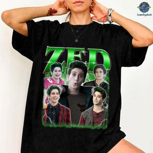 May include: Black t-shirt featuring the name "ZED" in large, green, glowing letters. The shirt has a collage of images of a young man with green hair. The design is framed with a green border and lightning bolt graphics.