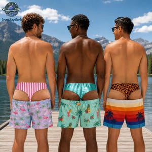May include: Three pairs of swim shorts worn over matching thongs. The left pair is light purple with pink flamingos and palm trees, paired with pink and white stripes. The centre is light blue with tropical drinks, paired with solid light blue. The right pair features a sunset gradient with palm trees, paired with a brown leopard print.