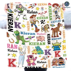 a person is holding a blanket with cartoon characters on it