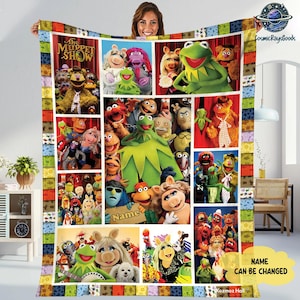 May include: A colorful fleece blanket featuring a collage of Muppet Show characters. The blanket showcases Kermit the Frog, Miss Piggy, Fozzie Bear, and other beloved characters. The border has a patchwork design, and the text "The Muppet Show" is visible.
