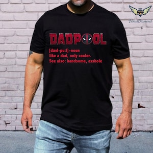May include: Black t-shirt with the word "DADPOOL" in red, featuring a Deadpool mask graphic. Below, a definition reads "like a dad, only cooler." The text also includes "See also: handsome, asshole."