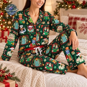 May include: A dark green long-sleeve button-down pyjama shirt and matching trousers set featuring a repeating pattern of Muppets characters in festive holiday attire, including Santa hats, surrounded by decorative frames and Christmas elements.
