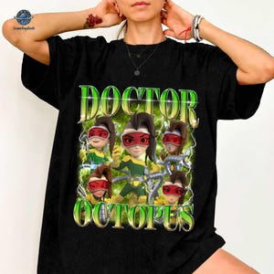 A person wearing a black t-shirt with a graphic design featuring a character named Doctor Octopus surrounded by various other characters.