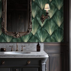 Puede incluir: Un baño con un tocador gris oscuro, encimera de mármol y un gran espejo ornamentado. La pared presenta un patrón geométrico verde y dorado. Una lámpara de pared y una botella marrón también son visibles.