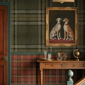 May include: A room featuring a framed painting of two dogs, set against a backdrop of plaid wallpaper in green, red, and brown. A wooden table with decorative items sits below the artwork, enhancing the room's classic aesthetic.