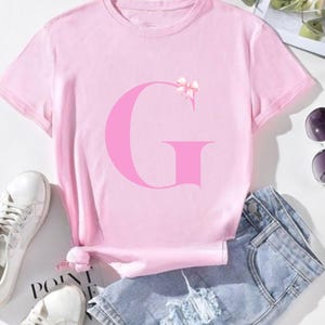 Camiseta pessoal com letra de fita rosa, camiseta inicial fofa para aniversários, presente para ela, roupa de algodão macio, camiseta gráfica alegre
