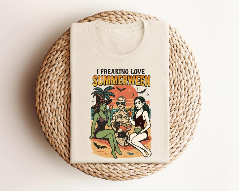 May include: Beige t-shirt with a graphic featuring three figures in swimwear, palm trees, bats, and the text "I FREAKING LOVE SUMMERWEEN." The design has a vintage, cartoon style with a Halloween theme.