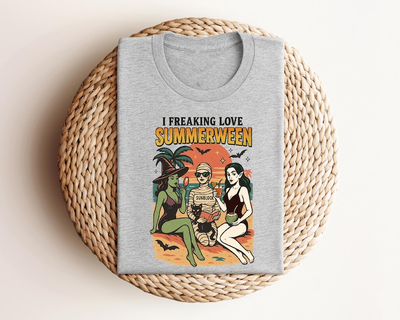 May include: A heather gray t-shirt with the words "I Freaking Love Summerween" above a colorful graphic. The graphic depicts three figures in swimwear, a black cat, palm trees, bats, and the word "Sunblock".