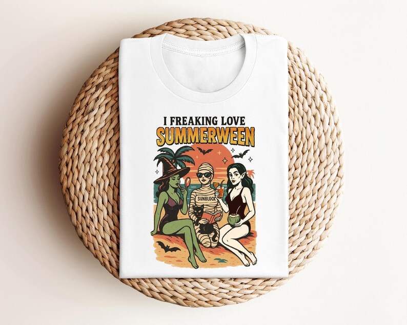 May include: White t-shirt with a graphic featuring three cartoon figures in swimwear on a beach, with the text "I Freaking Love Summerween." The design includes bats, palm trees, and a sunset.
