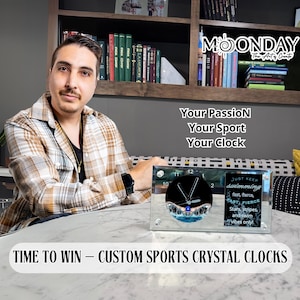 May include: A crystal clock with a black face and silver hands. The clock is surrounded by a blue wave design. The clock is on a white surface with the text "JUST KEEP SWIMMING fast, fierce,  ABT FIERCE Stars, stripes, and swim vibes only!" on the right side. The text "TIME TO WIN - CUSTOM SPORTS CRYSTAL CLOCKS" is at the bottom of the image.
