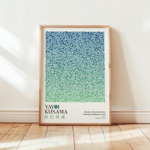 Könnte beinhalten: Ein gerahmter Kunstdruck mit einem Muster aus blau-grünen Kreisen. Der Druck enthält den Text "YAYOI KUSAMA" und japanische Schriftzeichen sowie "Eternity of Eternal Eternity" und "OSAKA 2012". Das Kunstwerk wird auf einem Holzboden präsentiert.
