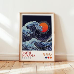 以下が含まれることがあります： 額縁に入ったアートプリント。大きな波と夕日をスタイリッシュに表現。青と白を基調とし、オレンジ色の太陽と濃い青色の背景。テキストには「Yayoi Kusama Tokyo」と日本語の文字が含まれています。