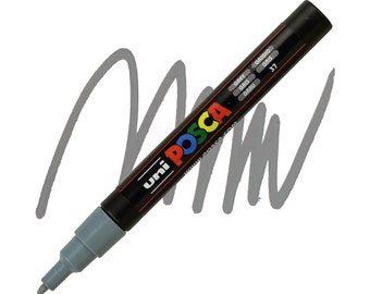 May include: A gray Uni Posca paint marker with a black cap. The marker has the text "Uni Posca" and "www.posca.com" printed on the side. The marker is labeled with the color "Gray" in multiple languages.