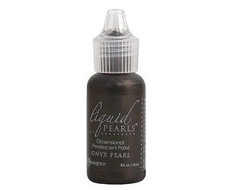 May include: A small bottle of Liquid Pearls Dimensional Pearlescent Paint in Onyx Pearl. The bottle is dark brown with a clear plastic cap and a dropper.