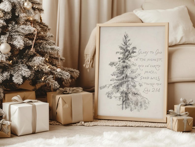 May include: A framed print featuring a pencil sketch of a Christmas tree and the text "Glory to God in the highest, and on earth peace, good will toward men Luke 2:14." The print is next to a decorated Christmas tree and wrapped gifts.