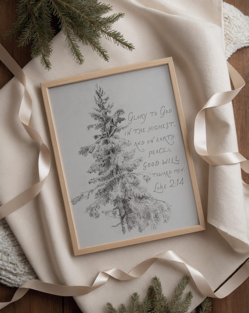 May include: A framed print with a pencil sketch of a snow-covered evergreen tree. The artwork is in a light wood frame and features the text "Glory to God in the Highest, and on Earth peace, good will toward men. Luke 2:14."