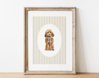 以下が含まれることがあります： 青いリボンをつけた茶色の犬の水彩画の額入りプリント。クリーム色と青色の花柄の壁紙の背景。犬は楕円形のフレームに収められています。アートワークは木製のフレームに展示されています。