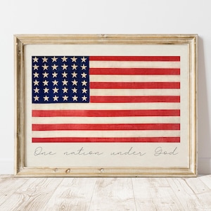 Può includere: Una stampa incorniciata di una vecchia bandiera americana con 48 stelle. La bandiera è sbiadita e ha un aspetto vintage. Il testo "One nation under God" è stampato sotto la bandiera.