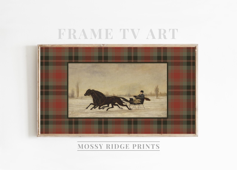 K&ouml;nnte beinhalten: Gerahmter Druck mit einer Winterszene, in der zwei schwarze Pferde einen Schlitten durch den Schnee ziehen. Das Kunstwerk ist von einem rot-gr&uuml;n-braunen Karomuster umgeben. Der Text "FRAME TV ART" und "MOSSY RIDGE PRINTS" sind sichtbar.