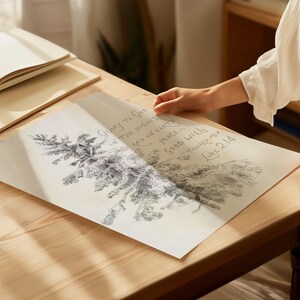 May include: A detailed black and white drawing of a tree branch with text from Luke 2:14. The text reads "Glory to God in the highest and on earth peace, good will toward men." The drawing is on a cream-colored paper, resting on a wooden table.