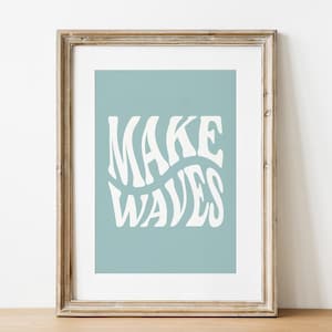 May include: A framed print with a light blue background and white text that reads "MAKE WAVES" in a wavy font.
