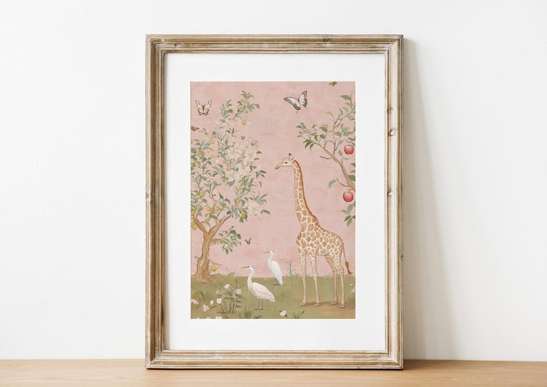 May include: Framed art print featuring a giraffe, two white birds, and butterflies in a whimsical garden scene. The artwork has a pink background with trees and apples. The frame is a light brown color.