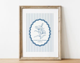 Puede incluir: Una impresión de arte imprimible azul y blanca con un marco ovalado azul que presenta un dibujo de línea de un lirio y el texto "Considera los lirios del campo" Mateo 6:28.