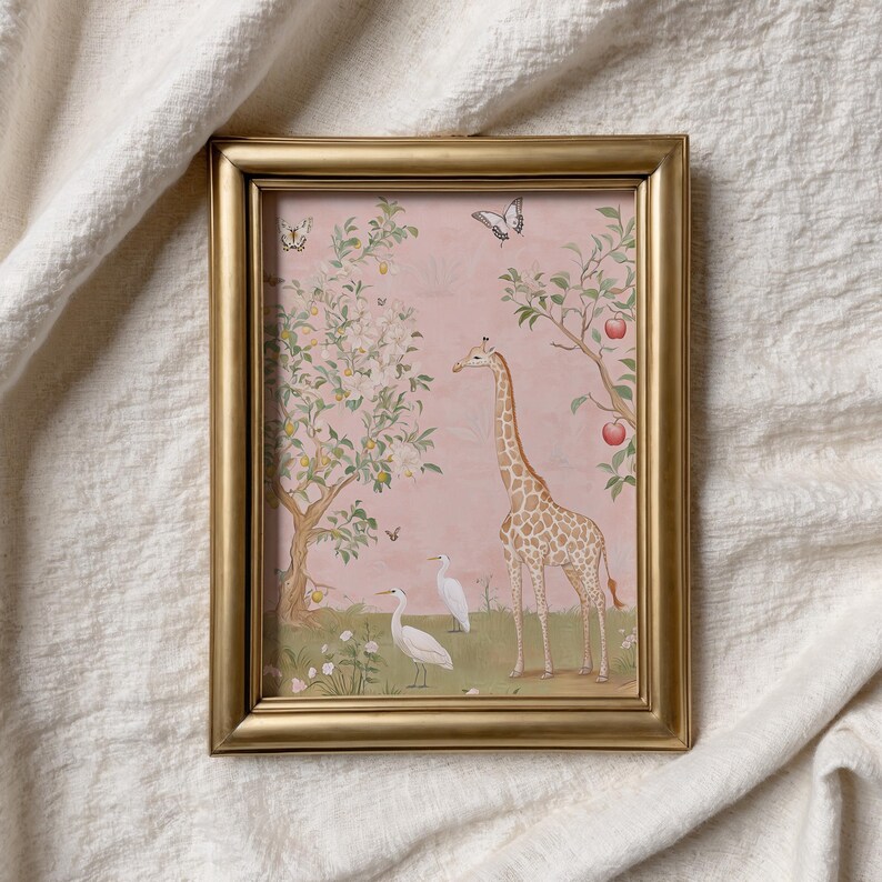 May include: A framed print featuring a giraffe, two white birds, and butterflies in a whimsical garden scene. The artwork has a pink background with trees bearing fruit and flowers. The frame is gold.