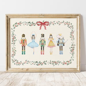 May include: A framed print featuring watercolor illustrations of characters from The Nutcracker ballet. The characters include a nutcracker soldier, a ballerina, and other figures, all framed by a garland of holly and a red bow.