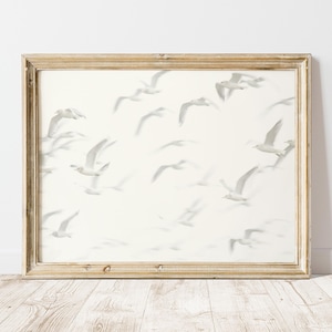 May include: A framed print of a white background with a flock of gray birds in flight. The birds are all facing the same direction and are flying in a loose formation.
