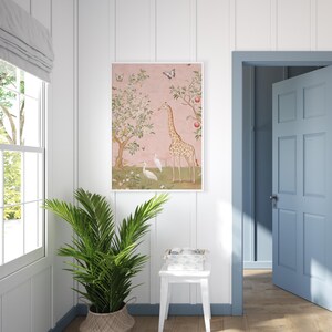 May include: A framed art print featuring a giraffe, birds, and butterflies in a whimsical garden scene. The artwork has a pink background with trees and flowers. The print is displayed in a white frame, adding a touch of elegance to the room.