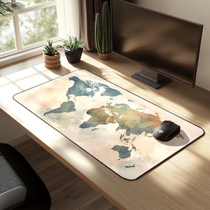 May include: A rectangular mouse mat featuring a watercolour world map design. The map shows continents in blue, green, and brown against a beige backdrop. A black wireless mouse is positioned on the right side of the mat.
