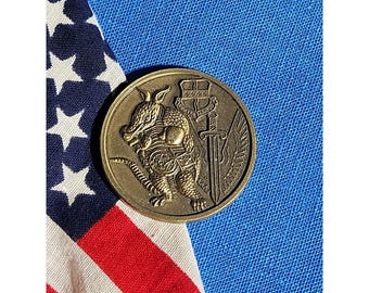 Moneda conmemorativa del 9.º Escuadrón de Apoyo Aéreo: Armadillo. Nos adaptamos a las circunstancias.