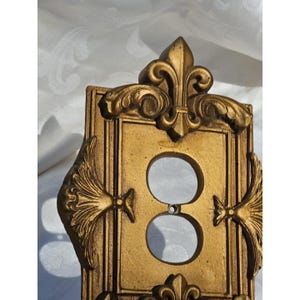 May include: A white ceramic mug with a black handle and the text "But First, Coffee" in a black, handwritten-style font. The mug is on a white surface.