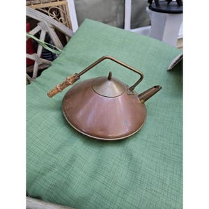 May include: A white ceramic mug with a black handle and the text "But First, Coffee" in a handwritten style. The mug is on a white surface. The mug is 4 inches tall.