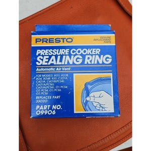 Puede incluir: Un recambio de junta de olla a presión Presto azul y amarillo. La caja presenta el logotipo de Presto, las palabras "Pressure Cooker Sealing Ring" y el número de pieza 09906. Está diseñado para varios modelos de ollas a presión Presto.