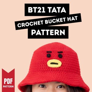 Puede incluir: Un sombrero de cubo rojo de ganchillo con una cara de dibujos animados, ojos negros y boca amarilla. El sombrero tiene el texto "BT21 TATA CROCHET BUCKET HAT PATTERN" en blanco sobre fondo negro. También hay un patrón PDF disponible.