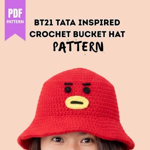 Könnte beinhalten: Ein roter Häkeleimerhut mit einem Cartoon-Gesicht-Design, inspiriert von BT21 Tata. Der Hut hat schwarze Augen und einen gelben Mund. Das Bild enthält auch den Text "PDF PATTERN" und "BT21 TATA INSPIRED CROCHET BUCKET HAT PATTERN."