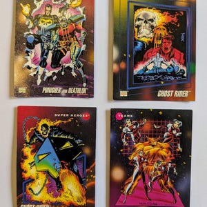 May include: Four vintage Marvel comic trading cards. The cards feature colorful illustrations of comic book characters, including Ghost Rider, Punisher, and Alpha Flight. The cards have text that reads "Team-Ups", "Origins", "Super Heroes", and "Teams".