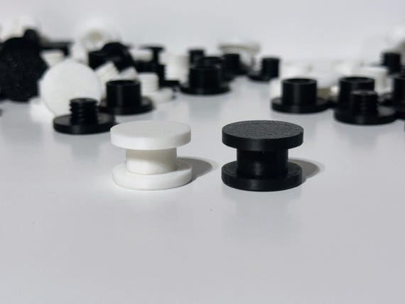 3D printed DIY Bogg Bag charm backers in white and black, flatlay